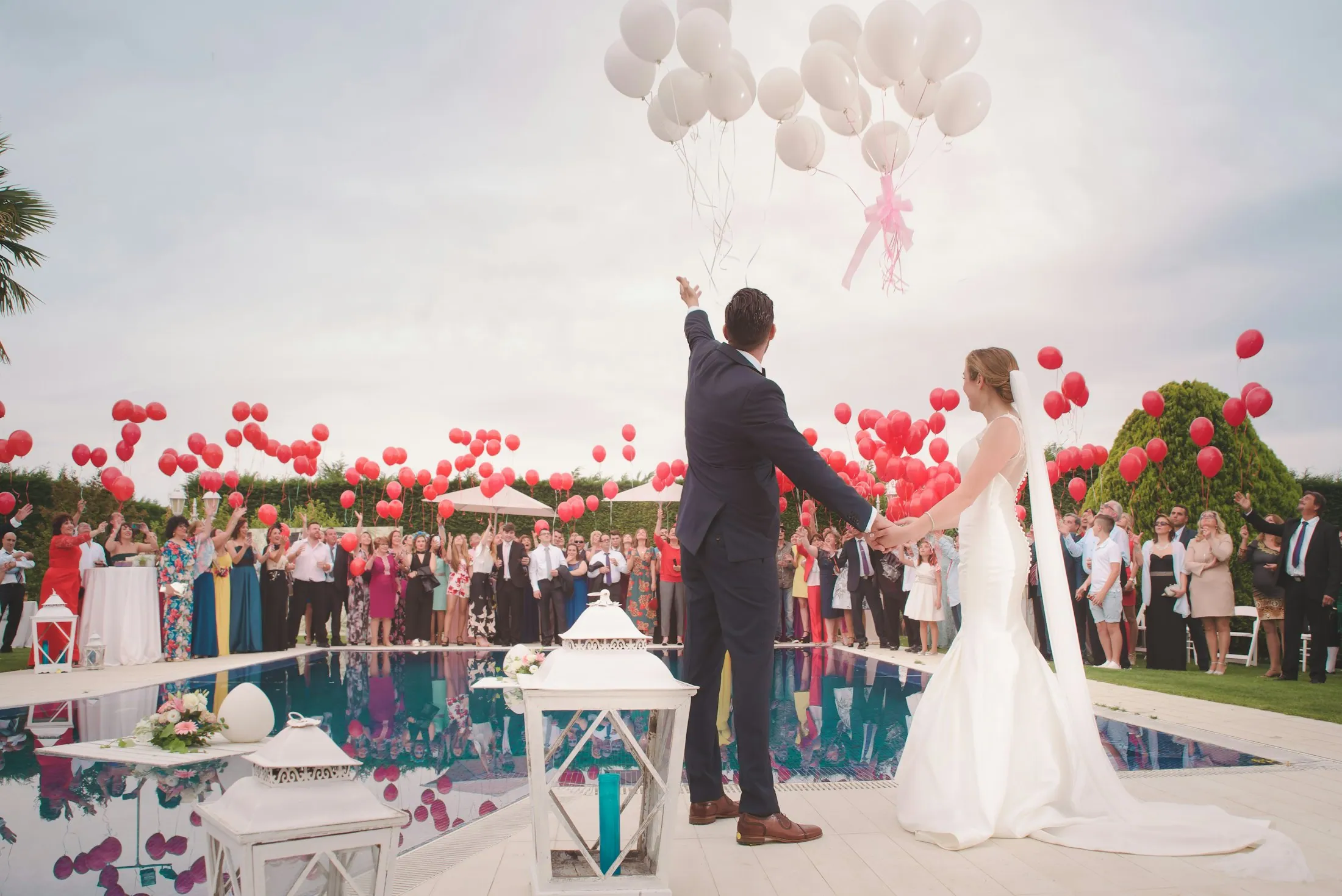 A couple celebrating with their guests amid confetti and balloons